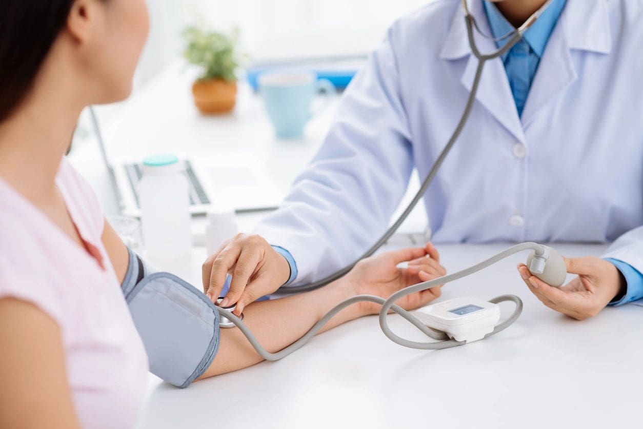 A doctor is checking the blood pressure of someone.